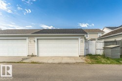 Two-car garage featuring panel-style doors and exterior wall sconces - 