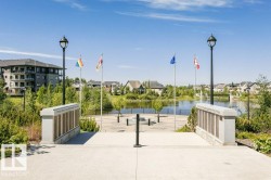 Water feature, surrounding landscaping, paved walkway, integrated lighting, and stone monument - 