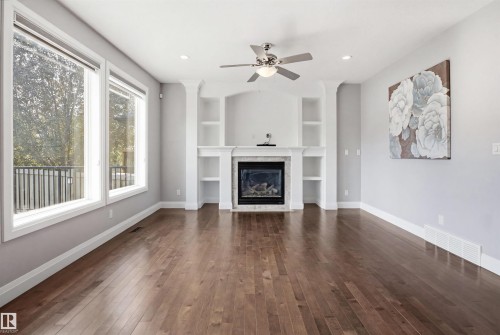 Hardwood flooring, built-in shelving, fireplace, ceiling fan with integrated lighting, and recessed lighting - 427 Windermere Road Nw, Edmonton, AB - Indoor Photo Showing Living Room With Fireplace