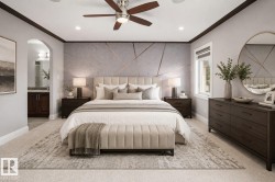 Spacious sleeping area with a geometric accent wall, recessed lighting, and a ceiling fan - 