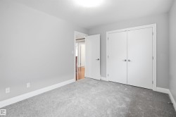Gray wall paint with white trim, gray carpet flooring, white bi-fold closet doors, and white interior doors with satin nickel hardware - 