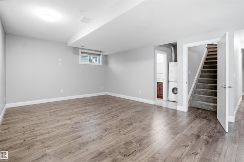 Spacious open area with wood-finish flooring, recessed ceiling light, and a window - 427 Windermere Road Nw, Edmonton, AB - Indoor Photo Showing Other Room