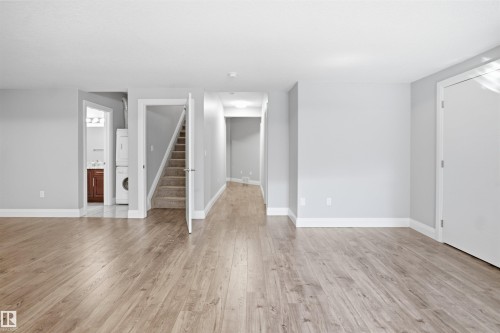 Wood-finish flooring throughout, light gray wall paint, white trim, and white interior doors - 427 Windermere Road Nw, Edmonton, AB - Indoor Photo Showing Other Room