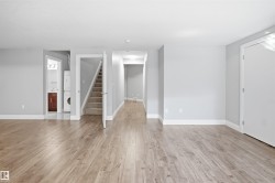Wood-finish flooring throughout, light gray wall paint, white trim, and white interior doors - 