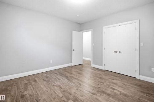 Wood-finish flooring with light gray walls and white trim - 427 Windermere Road Nw, Edmonton, AB - Indoor Photo Showing Other Room