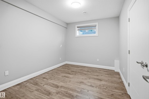 Neutral gray walls, wood-finish flooring, and white trim - 427 Windermere Road Nw, Edmonton, AB - Indoor Photo Showing Other Room