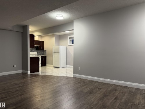 Wood-finish flooring, recessed lighting, dark wood cabinetry, white countertops, and a subway tile backsplash - 427 Windermere Road Nw, Edmonton, AB - Indoor