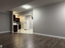 Wood-finish flooring, recessed lighting, dark wood cabinetry, white countertops, and a subway tile backsplash - 