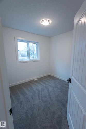 Neutral wall paint with textured carpeting, a window featuring white trim, and a flush mount ceiling light - 9632 #1 And #2 110 Ave Nw, Edmonton, AB - Indoor Photo Showing Other Room