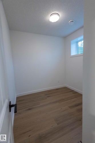 Recessed window, wood-finish flooring, white walls, flush mount ceiling light, contemporary door hardware - 9632 #1 And #2 110 Ave Nw, Edmonton, AB - Indoor Photo Showing Other Room