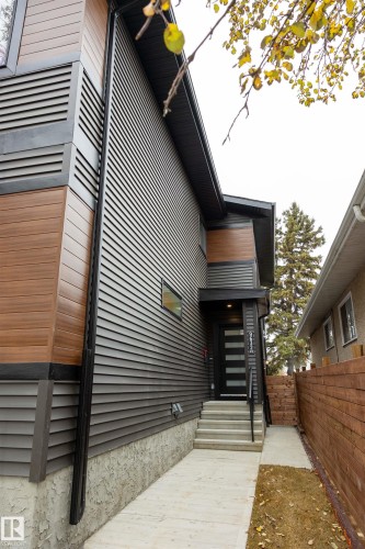 Modern exterior featuring horizontal dark siding, wood-finish accent panels, and a concrete pathway - 9632 #1 And #2 110 Ave Nw, Edmonton, AB - Outdoor With Exterior