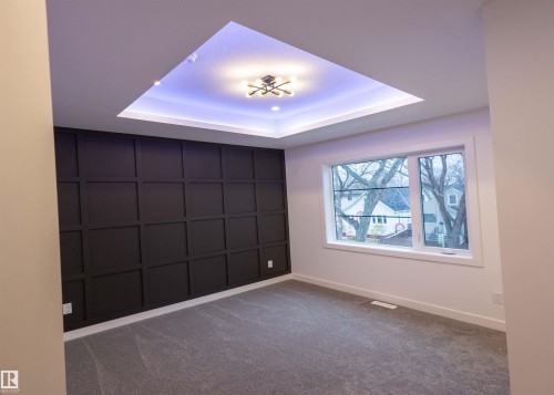 Tray ceiling with recessed lighting, central ceiling light fixture, panel accent wall, double-pane window, and carpet flooring - 9632 #1 And #2 110 Ave Nw, Edmonton, AB - Indoor Photo Showing Other Room