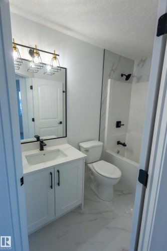 White vanity with a single basin sink and black faucet - 9632 #1 And #2 110 Ave Nw, Edmonton, AB - Indoor Photo Showing Bathroom