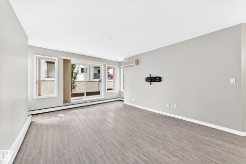 Neutral-toned walls complement the wood-finish flooring - #137 9704 174 St Nw, Edmonton, AB - Indoor Photo Showing Other Room