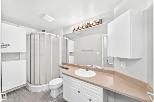 White vanity with an integrated sink and light-toned countertop - #137 9704 174 St Nw, Edmonton, AB - Indoor Photo Showing Bathroom