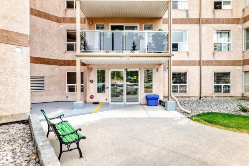 Entryway with glass doors, concrete walkway, and a green metal bench - #137 9704 174 St Nw, Edmonton, AB - Outdoor With Exterior