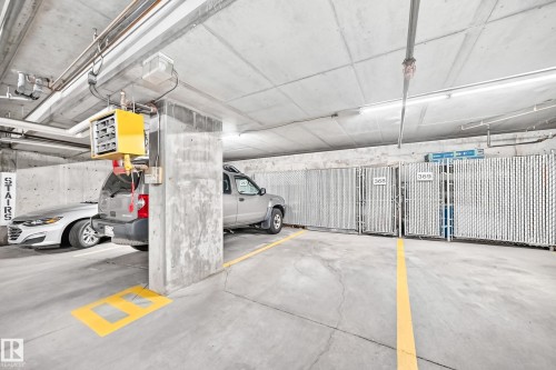 Concrete parking structure with designated spaces, concrete walls, and overhead lighting - #137 9704 174 St Nw, Edmonton, AB - Indoor Photo Showing Garage