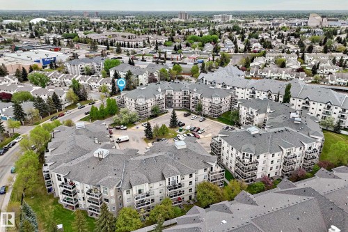 Apartment complex with multiple buildings, numerous balconies, and a central parking area - #137 9704 174 St Nw, Edmonton, AB - Outdoor With View