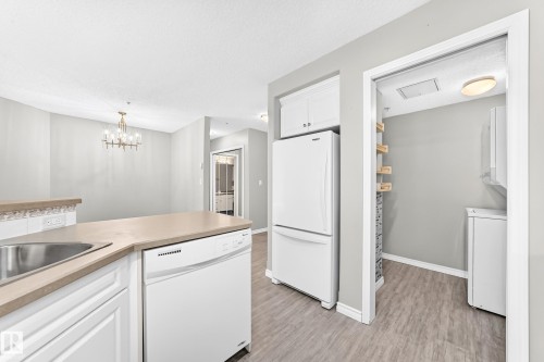 Kitchen featuring white cabinetry, a built-in dishwasher, and a stainless steel sink - #137 9704 174 St Nw, Edmonton, AB - Indoor Photo Showing Kitchen