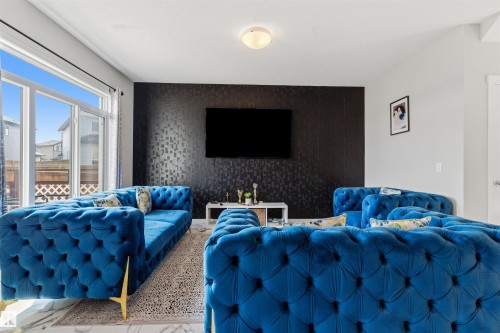 Expansive sliding glass doors, textured accent wall, and recessed ceiling light fixture - 1103 26 Avenue Nw, Edmonton, AB - Indoor Photo Showing Other Room