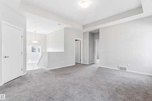 Gray carpeted flooring, light gray wall paint, white trim, white interior doors, and a flush mount ceiling light fixture - 1103 26 Avenue Nw, Edmonton, AB - Indoor Photo Showing Other Room