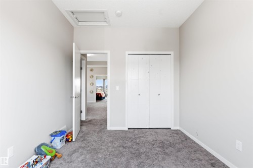 Neutral wall paint, gray carpeting, white bi-fold closet doors, white trim, and a white ceiling - 1103 26 Avenue Nw, Edmonton, AB - Indoor