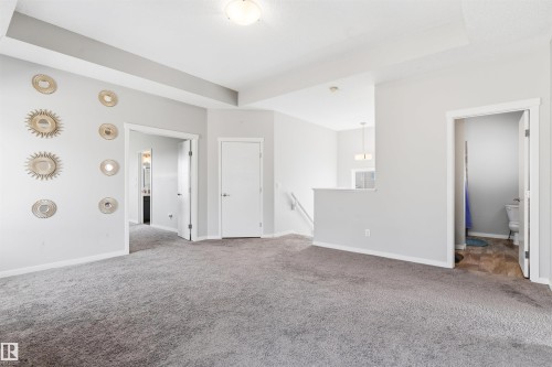 Neutral toned walls with gray carpeting, featuring a ceiling light fixture and white trim - 1103 26 Avenue Nw, Edmonton, AB - Indoor Photo Showing Other Room