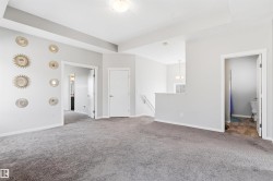 Neutral toned walls with gray carpeting, featuring a ceiling light fixture and white trim - 