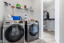 Laundry area featuring a front-load washer and dryer, wire shelving, and light gray wall paint - 
