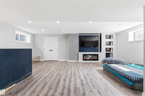 Wood-finish flooring, recessed lighting, and a built-in electric fireplace - 1103 26 Avenue Nw, Edmonton, AB - Indoor With Fireplace