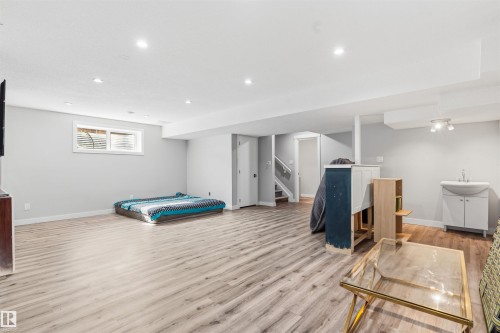 Spacious room featuring wood-finish flooring, recessed lighting, and a window with blinds - 1103 26 Avenue Nw, Edmonton, AB - Indoor