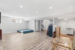 Spacious room featuring wood-finish flooring, recessed lighting, and a window with blinds - 