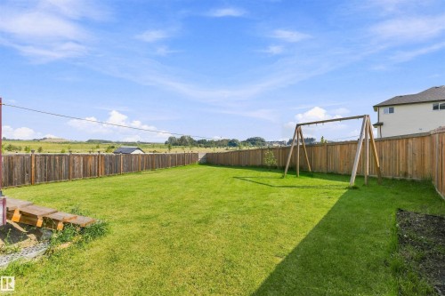 Expansive green lawn with a wood-panel fence enclosure - 1103 26 Avenue Nw, Edmonton, AB - Outdoor With Backyard