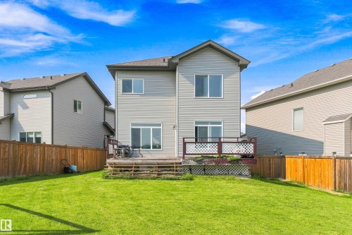 Expansive backyard with a manicured lawn, full privacy fencing, and a multi-level wooden deck - 1103 26 Avenue Nw, Edmonton, AB - Outdoor With Deck Patio Veranda
