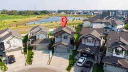 Contemporary two-story residence with a two-car garage, mature landscaping, and a paved driveway - 