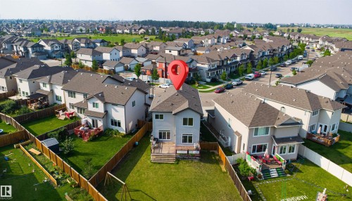 Rear exterior with light gray siding, a deck, and an expansive fenced yard - 1103 26 Avenue Nw, Edmonton, AB - Outdoor