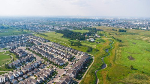 Aerial perspective showcasing a residential development with extensive green spaces and a winding creek - 1103 26 Avenue Nw, Edmonton, AB - Outdoor With View