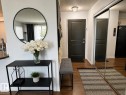 Dark paneled entry door, wood-finish flooring, and mirrored closet doors - #301 13907 136 St Nw, Edmonton, AB  - Indoor Photo Showing Other Room 