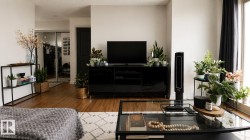 Hardwood-finish flooring, white wall finishes, dark trim, and a built-in media console - 