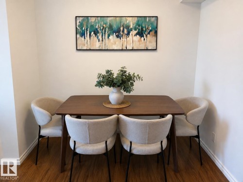 Light-toned walls complement wood-finish flooring - #301 13907 136 St Nw, Edmonton, AB - Indoor Photo Showing Dining Room
