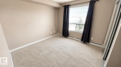 Neutral-toned carpeting, window with blinds and dark drapery, baseboard heating, and a mirrored closet door - 