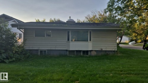 Light-colored horizontal siding with a bay window and foundation plantings - 25 Balmoral Drive, St. Albert, AB 