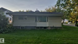 Light-colored horizontal siding with a bay window and foundation plantings - 