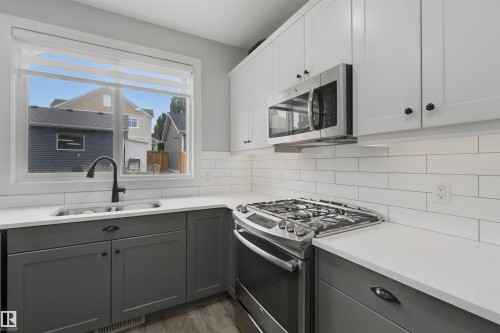 Kitchen featuring an undermount double basin sink, stainless steel range, and built-in microwave - 7603 Summerside Grande Boulevard Sw, Edmonton, AB - Indoor Photo Showing Kitchen With Double Sink With Upgraded Kitchen