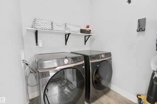 Wood-finish flooring with light-toned walls - 7603 Summerside Grande Boulevard Sw, Edmonton, AB - Indoor Photo Showing Laundry Room