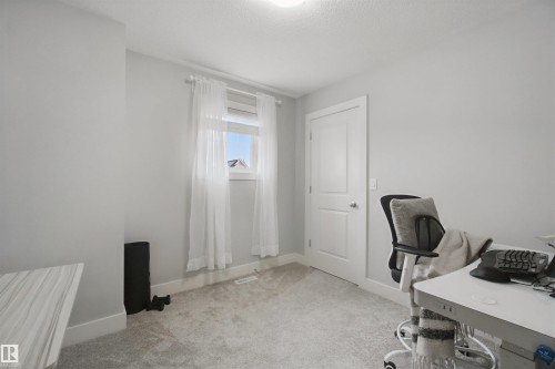 Carpeted room with light gray walls, a single window, and a white interior door with a silver handle - 7603 Summerside Grande Boulevard Sw, Edmonton, AB - Indoor Photo Showing Office