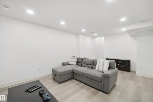 Recessed ceiling lighting, light wood-finish flooring, white painted walls, and built-in shelving - 7603 Summerside Grande Boulevard Sw, Edmonton, AB - Indoor Photo Showing Other Room