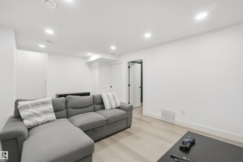 Recessed ceiling lighting, light wood-finish flooring, white walls, and a white interior door with black hardware - 7603 Summerside Grande Boulevard Sw, Edmonton, AB - Indoor