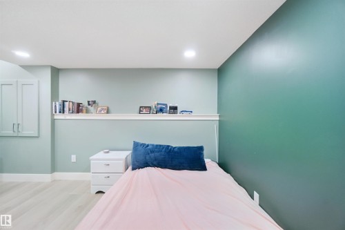 Recessed lighting, wood-finish flooring, built-in wall cabinets, and a white display shelf - 7603 Summerside Grande Boulevard Sw, Edmonton, AB - Indoor Photo Showing Bedroom