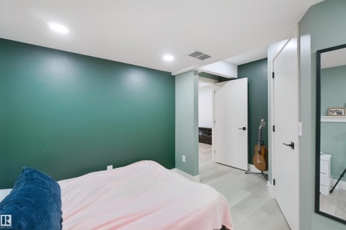 Recessed ceiling lighting, durable flooring, solid core doors with matte black hardware, and a built-in wall shelf - 7603 Summerside Grande Boulevard Sw, Edmonton, AB - Indoor Photo Showing Bedroom